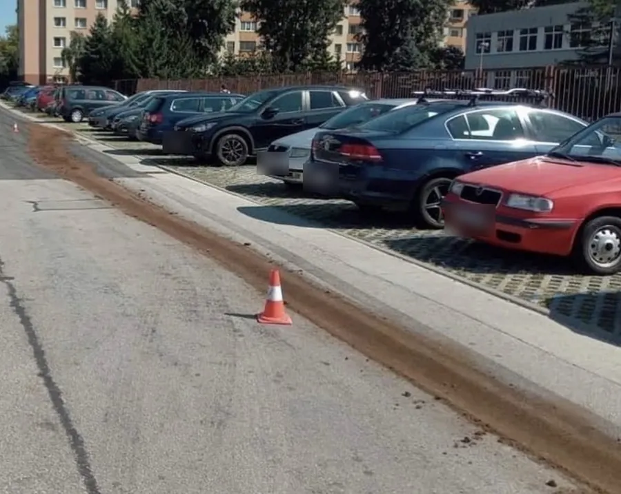 Pás sorbentu SORB®XT na ceste pozdĺž parkoviska, vedľa neho dopravný kužeľ